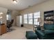 Cozy living room with a bookshelf, sofa, desk, and lots of natural light from the window at 1028 Dotson Way, Apex, NC 27523