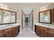 Spacious bathroom features dual sinks and vanities with wood cabinets, and a hallway to the bedroom at 109 Skywater Ln, Holly Springs, NC 27540
