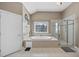 This bathroom has a soaking tub under a window, and a glass shower at 109 Skywater Ln, Holly Springs, NC 27540