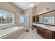 Bright bathroom featuring a soaking tub and separate glass shower adjacent to vanity and sink at 109 Skywater Ln, Holly Springs, NC 27540