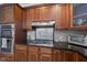Kitchen detail showing stainless steel appliances, dark countertops, and decorative backsplash at 109 Skywater Ln, Holly Springs, NC 27540