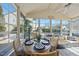Bright sunroom with large windows, ceiling fan, dining set, sofa, and a view of the pool at 109 Skywater Ln, Holly Springs, NC 27540
