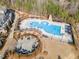Aerial view of the community pool area with lounge chairs and sunshades at 1100 Gaston Manor Dr, Durham, NC 27703