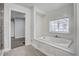 Bright bathroom featuring a soaking tub with a window and a glass-enclosed shower at 11254 Hwy Nc 50, Benson, NC 27504