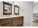 Double sink bathroom featuring wood cabinets, framed mirrors, and neutral paint at 11254 Hwy Nc 50, Benson, NC 27504