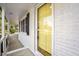 Close-up of a bright yellow front door framed by white brick and black shutters at 11254 Hwy Nc 50, Benson, NC 27504