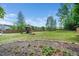 Expansive backyard with a playset, surrounded by mature trees and a wooden fence, perfect for outdoor activities and privacy at 115 Lockamy Ln, Youngsville, NC 27596