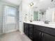 Well-lit bathroom featuring a double vanity with dark cabinetry and tile floors at 115 Lockamy Ln, Youngsville, NC 27596