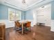 Dining room with hardwood floors, wainscoting, a tray ceiling, and a view of the front yard at 115 Lockamy Ln, Youngsville, NC 27596