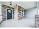 Close-up of front porch showcasing the stone accents, stylish door, and modern outdoor lighting at 115 Lockamy Ln, Youngsville, NC 27596