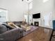 Cozy living room featuring a fireplace, hardwood floors, and large windows for ample light at 115 Lockamy Ln, Youngsville, NC 27596