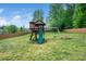 Backyard play structure features a slide, swings, and elevated fort, all enclosed by a wooden perimeter fence at 115 Lockamy Ln, Youngsville, NC 27596