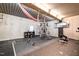 A workout area featuring a full gym setup, concrete walls, and a high ceiling with exposed beams and rubber flooring at 12345 Beestone Ln, Raleigh, NC 27614