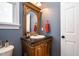 Elegant half-bathroom with a decorative mirror, granite countertop, and stylish fixtures at 12345 Beestone Ln, Raleigh, NC 27614