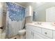 Well-lit bathroom featuring a bathtub-shower with a decorative curtain, a toilet, and a white vanity at 12345 Beestone Ln, Raleigh, NC 27614