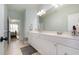 Bright bathroom featuring double vanity, white cabinetry, and tile flooring, with the bedroom visible in the background at 12345 Beestone Ln, Raleigh, NC 27614