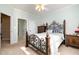 Light-filled bedroom with a decorative wrought iron bed frame, carpet, and a view into the hallway at 12345 Beestone Ln, Raleigh, NC 27614