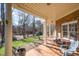 Inviting covered porch features brick accents, a view of the landscaped yard, and outdoor seating at 12345 Beestone Ln, Raleigh, NC 27614