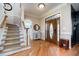 Elegant foyer featuring hardwood floors, staircase, and a decorative front door at 12345 Beestone Ln, Raleigh, NC 27614