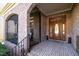 Covered front porch with brick arches leading to an ornate wooden front door at 12345 Beestone Ln, Raleigh, NC 27614