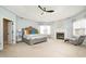 Spacious main bedroom featuring a tray ceiling, fireplace, chaise lounge, and neutral tones at 12345 Beestone Ln, Raleigh, NC 27614