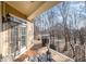 Covered porch with a grill, dining set, and wooded backyard, creating an ideal outdoor space at 12345 Beestone Ln, Raleigh, NC 27614