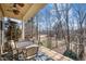 Relaxing covered porch with ceiling fan, table and chairs, overlooking a wooded golf course view in the distance at 12345 Beestone Ln, Raleigh, NC 27614
