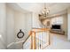 Bright staircase with wood handrail and white spindles and globe chandelier is a bright feature of the home at 12345 Beestone Ln, Raleigh, NC 27614