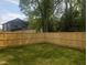 Spacious fenced backyard with a well-maintained lawn and natural tree coverage at 1410 Joe Louis Ave, Raleigh, NC 27610