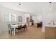Well-lit dining area with a modern white table, hardwood floors, and open flow to the kitchen at 1410 Joe Louis Ave, Raleigh, NC 27610