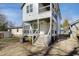 Backyard view of a two-story home that features a walkout patio, porch, and manicured lawn at 1410 Joe Louis Ave, Raleigh, NC 27610