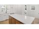 Kitchen island with seating and quartz countertop adjacent to sink and stainless steel appliances at 1410 Joe Louis Ave, Raleigh, NC 27610