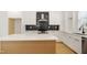 Bright kitchen features an island with quartz countertop, stainless steel appliances, and stylish black backsplash at 1410 Joe Louis Ave, Raleigh, NC 27610