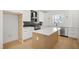 Bright, open-concept kitchen features an island with quartz countertop, stainless steel appliances, and stylish black backsplash at 1410 Joe Louis Ave, Raleigh, NC 27610