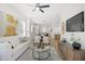Open-concept living room with hardwood floors, modern furnishings, and a view into the dining and kitchen areas at 1410 Joe Louis Ave, Raleigh, NC 27610