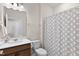 Well-lit bathroom with a wood vanity, modern sink, and patterned shower curtain at 1413 Buxus Ct, Fuquay Varina, NC 27526