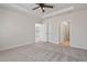 Empty bedroom featuring large windows with a tray ceiling, a ceiling fan, carpeted floors, and lots of natural light at 1413 Buxus Ct, Fuquay Varina, NC 27526