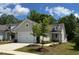Charming home featuring a light-colored exterior, well-manicured lawn, and a two-car garage at 1413 Buxus Ct, Fuquay Varina, NC 27526