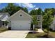 Inviting home with a two-car garage, neutral exterior, and a beautifully landscaped front yard at 1413 Buxus Ct, Fuquay Varina, NC 27526