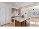 Open kitchen with an island, white countertops, wooden cabinets, and access to living area at 1413 Buxus Ct, Fuquay Varina, NC 27526