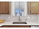 Neutral-toned kitchen area features a large sink, a window overlooking the exterior, and a white countertop at 1413 Buxus Ct, Fuquay Varina, NC 27526