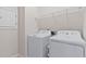 Efficient laundry area with a white washer and dryer and wire shelving at 1413 Buxus Ct, Fuquay Varina, NC 27526