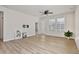 Living room with hardwood floors, light-colored walls, ceiling fan, large windows and view of the front yard at 1413 Buxus Ct, Fuquay Varina, NC 27526