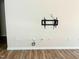 Empty living room with hardwood floors, light-colored walls, wall-mounted tv bracket, and electric outlets at 1413 Buxus Ct, Fuquay Varina, NC 27526
