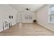 Bright and airy living room with wood-look flooring, large windows, and access to the backyard at 1413 Buxus Ct, Fuquay Varina, NC 27526