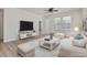 Bright living room with hardwood floors, ceiling fan, white walls and furniture, and lots of natural light at 1413 Buxus Ct, Fuquay Varina, NC 27526