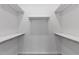 Walk-in closet with white walls and trim, carpeted floors and shelving to maximize storage space at 1413 Buxus Ct, Fuquay Varina, NC 27526