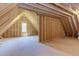 Unfinished attic space with a window, showcasing the wood frame construction at 15 Harvest View Way, Franklinton, NC 27525