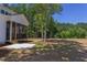 Backyard with covered porch, mature trees, and a concrete patio area at 15 Harvest View Way, Franklinton, NC 27525