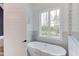 Stylish bathroom with a freestanding tub, a window for natural light, and decorative tile accents at 15 Harvest View Way, Franklinton, NC 27525